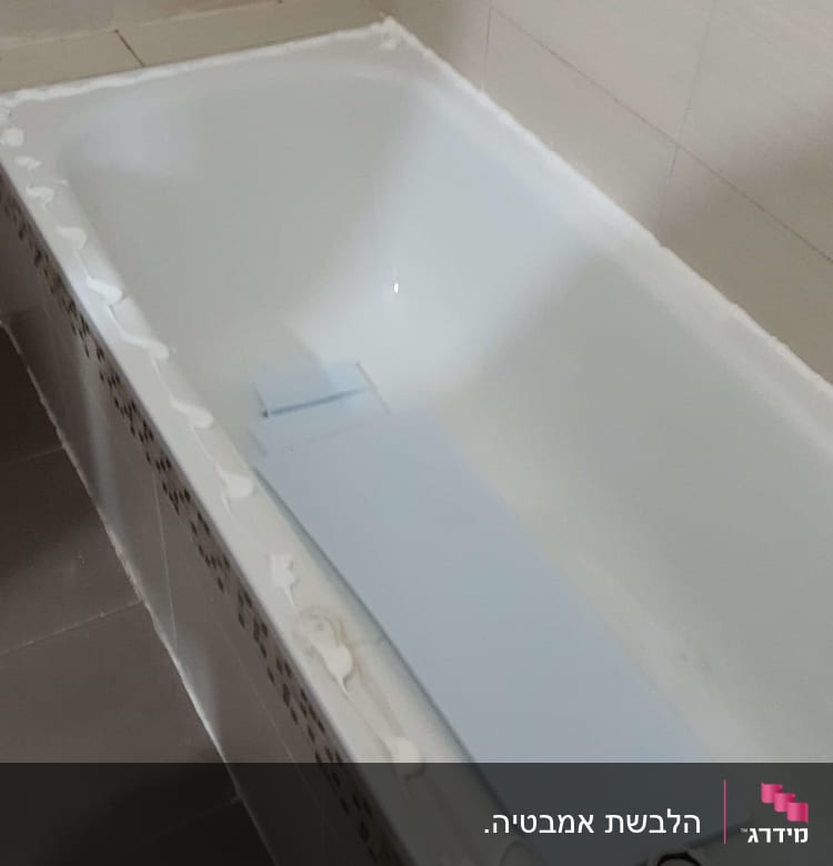 אמבטיה עם חומר איטום לבן על השוליים